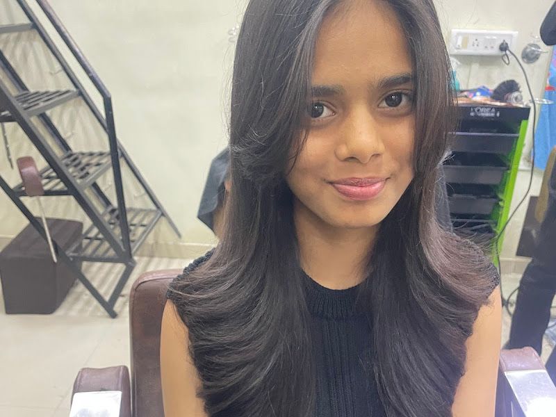Sleek long layered cut with a bouncy flick, young female client at the chair. — The Rush Family Salon, Airoli, Navi Mumbai