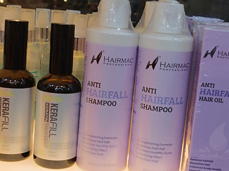 Retail shelf of HairMac anti-hairfall range — shampoo, hair oil, kerafill and hair serum bottles. — The Rush Family Salon, Airoli, Navi Mumbai