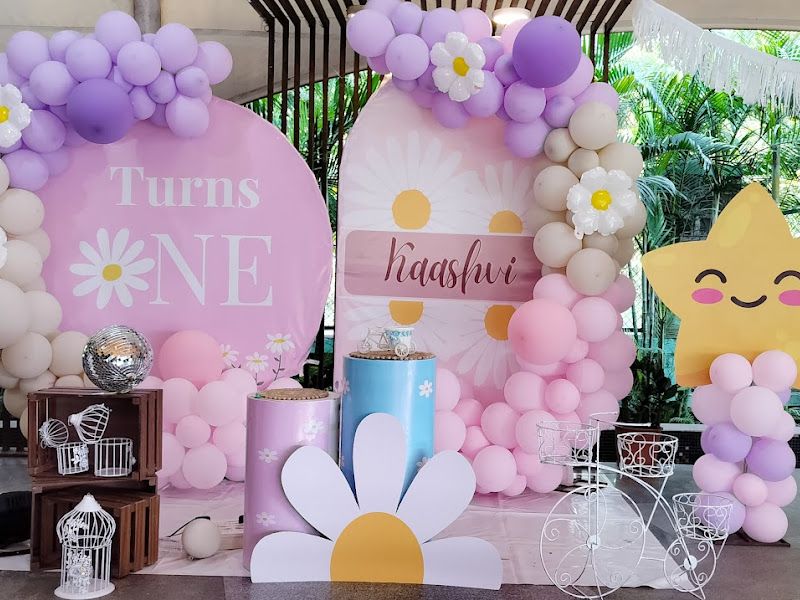 Daisy pastel 1st birthday ('Turns One') — outdoor balloon arches with daisy backdrops and a smiling star cutout — Arya Events Planner, Kharghar, Navi Mumbai