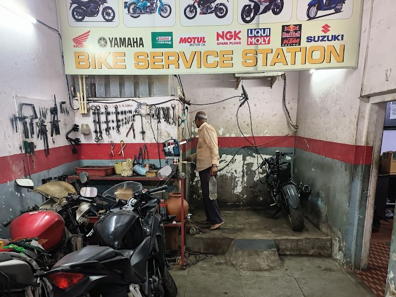 Interior with parked customer bikes and spare-parts dealer signage, EV poster wall — The Bike Shoppy, Vashi, Navi Mumbai