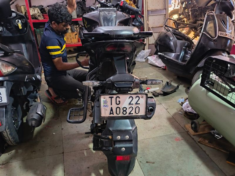Workshop interior — 'Bike Service Station' wall with brand boards (Yamaha, Motul, NGK, Suzuki), tool wall and service bay — The Bike Shoppy, Vashi, Navi Mumbai
