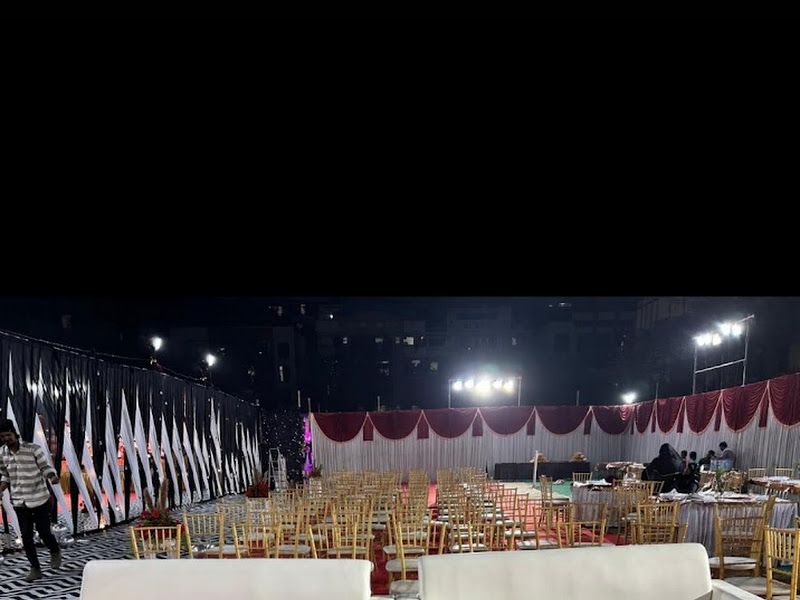 Stage-side VIP seating — white sofas on a red carpet inside a large decorated hall — Arya Events Planner, Kharghar, Navi Mumbai