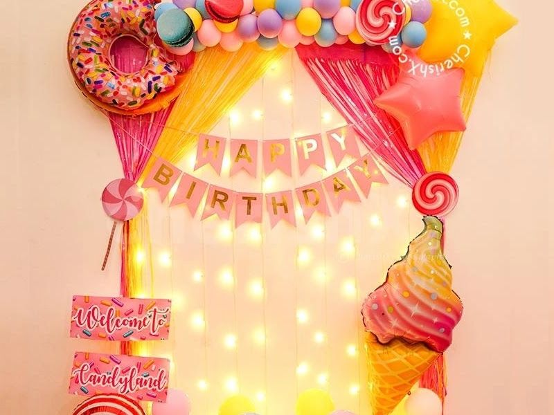 Candyland home backdrop — sheer curtain with fairy lights, donut/ice-cream/lollipop foils and a 'Welcome to Candyland' sign — Arya Events Planner, Kharghar, Navi Mumbai