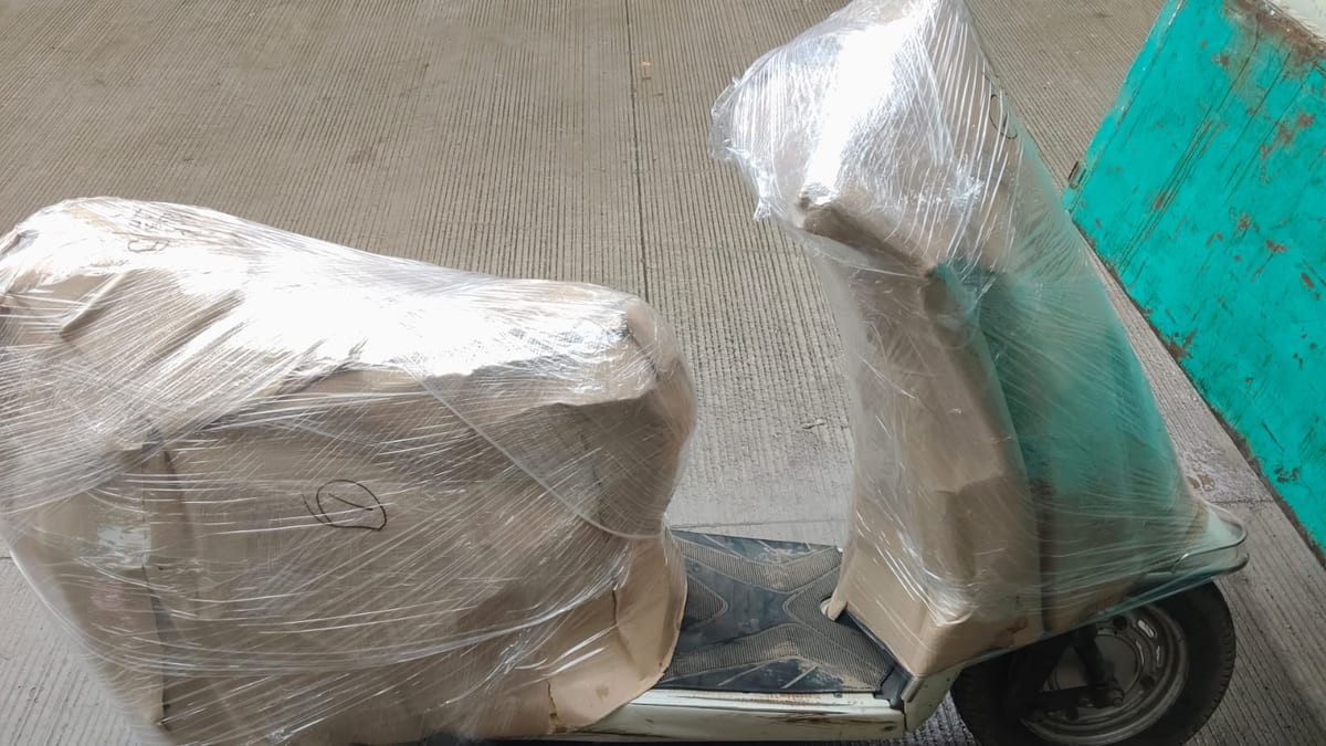 Wrapped items secured on a wheeled hand truck for shifting