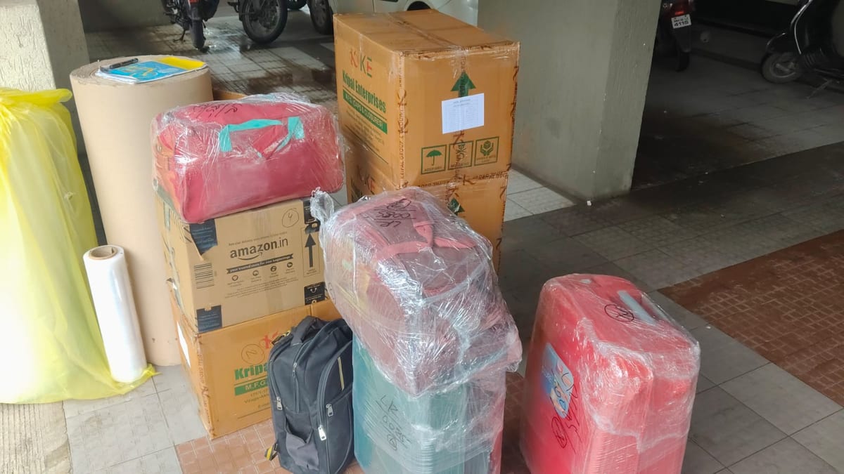 Plastic-wrapped parcels, cardboard boxes and packing material near a building entrance